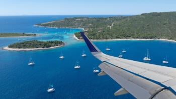 airplane flying over lagoon catamarans in croatia